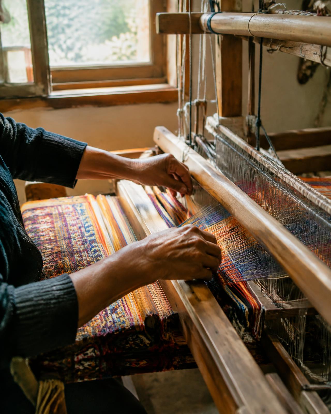 Artisan hands weaving on a loom